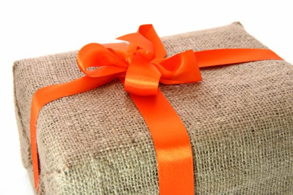 large gift box wrapped by burlap canvas with orange bow