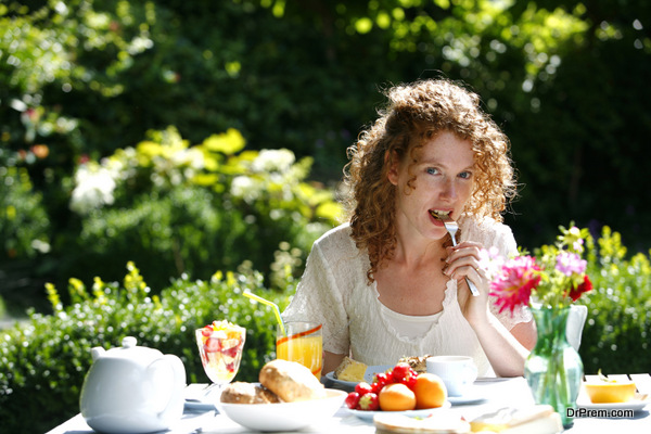A beautiful woman eating a meal in her garden