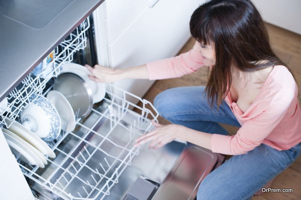 middle aged girl in the kitchen using dishwasher