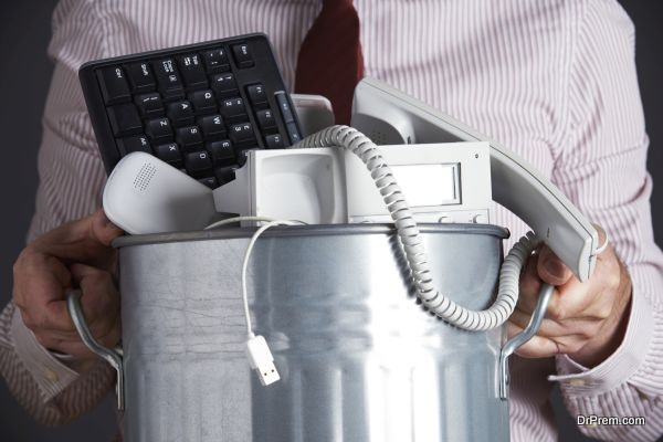 Businessman Holding Garbage Can With Obsolete Office Equipment