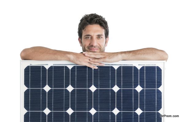 Smiling man showing and holding a solar panel isolated on white background