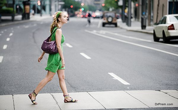 Woman walking in crosswalk in city