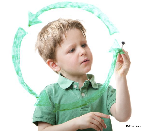 Little boy drawing recycling symbol on glass. Isolated on white.
