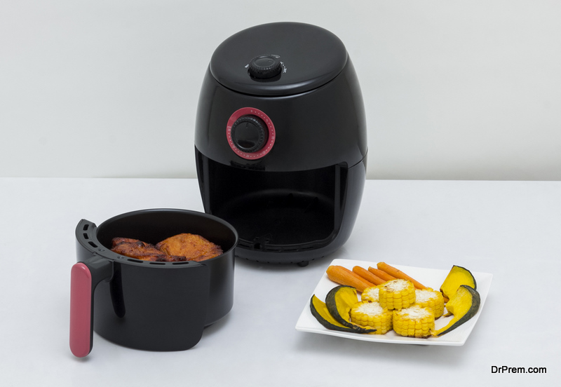 Air fryer machine with chicken and vegetables