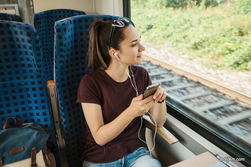 Una niña escucha música o podcasts en el tren.