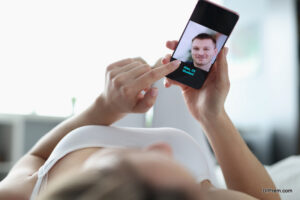 Woman lying in bed and using mobile phone